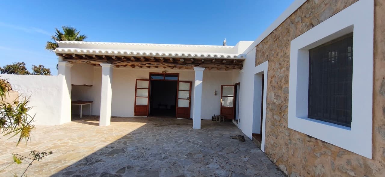 Whitewashed courtyard with a contemporary window opening at Can Delfin, Sant Llorenc de Balafia, Ibiza