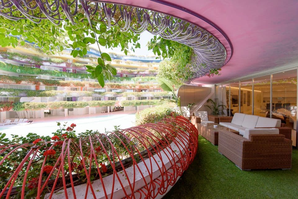 Living space within the Las Boas building, with its planted curved balconies beyond, Ibiza