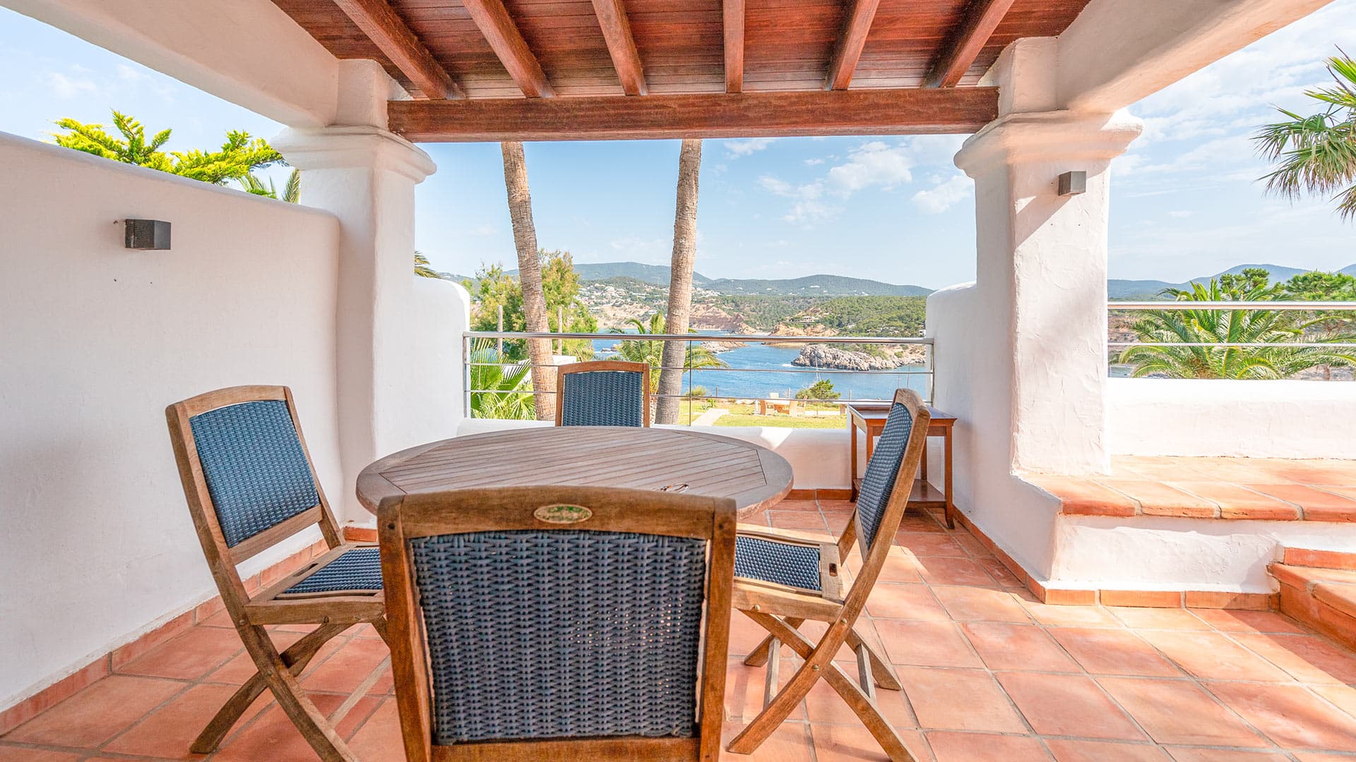 Covered terrace with a table looking out over the bay at Casa Porroig, Es Cubells, Ibiza