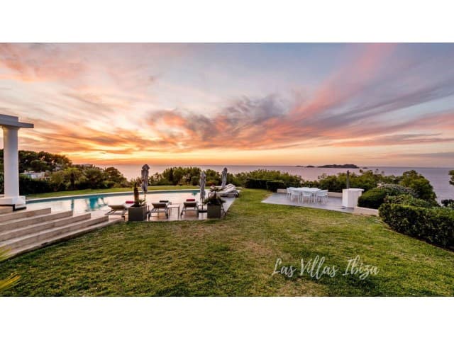 Sunset over the lawn and pergola looking out to sea at Can Rasa, Sant Josep, Ibiza