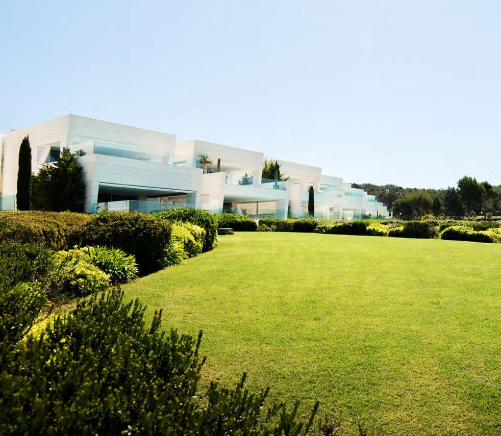 Wide lawns running from the building to the sea at Piso Esmeralda, Marina Botafoc, Ibiza