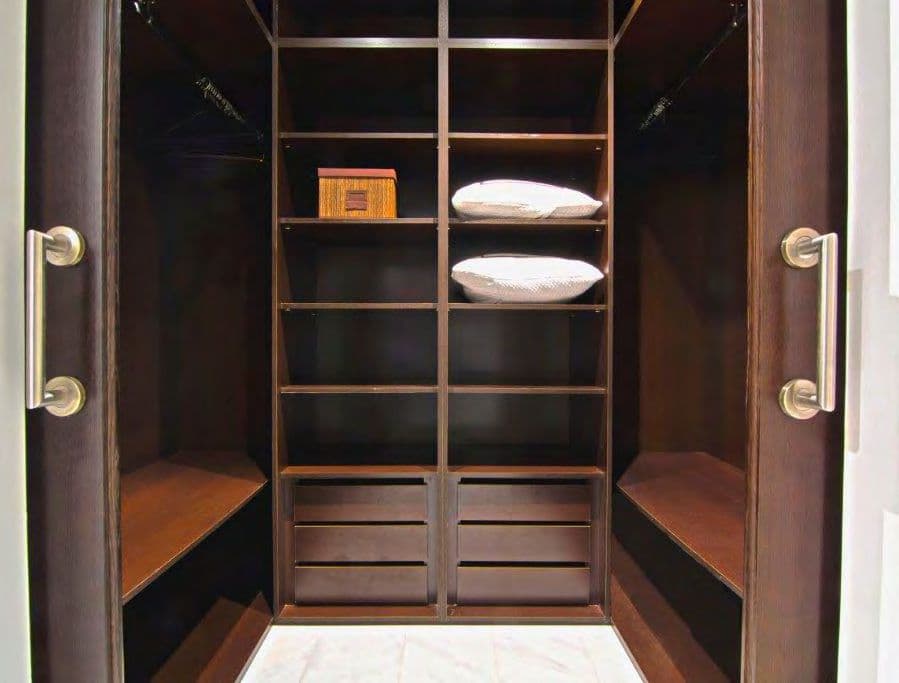 Fitted dressing room in dark timber with open shelving at Piso Zafiro, Marina Botafoc, Ibiza