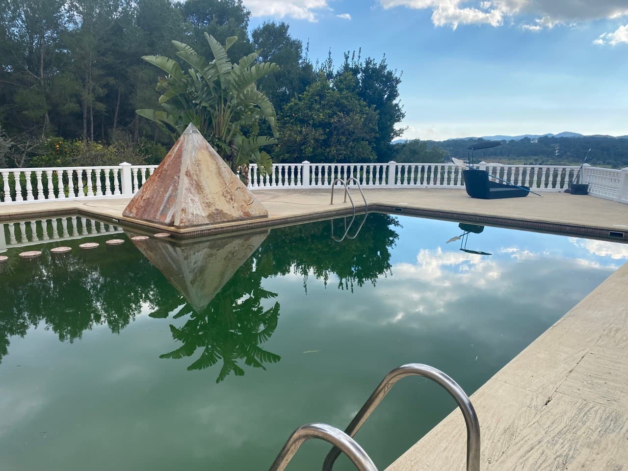 The pyramid feature reflected in the still pool water at Sa Freesia, Santa Eularia, Ibiza