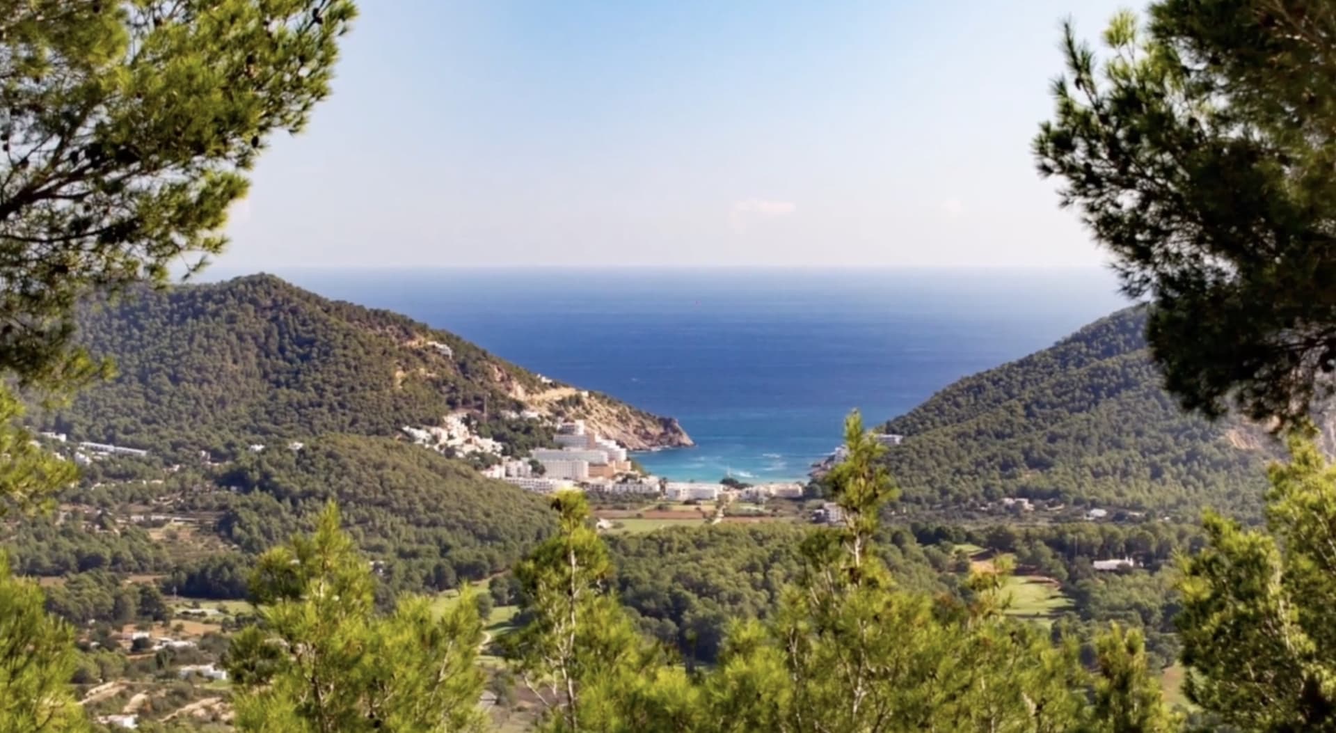 View from Can Loto over pine covered hills to the bay and beach below, Jesus, Ibiza