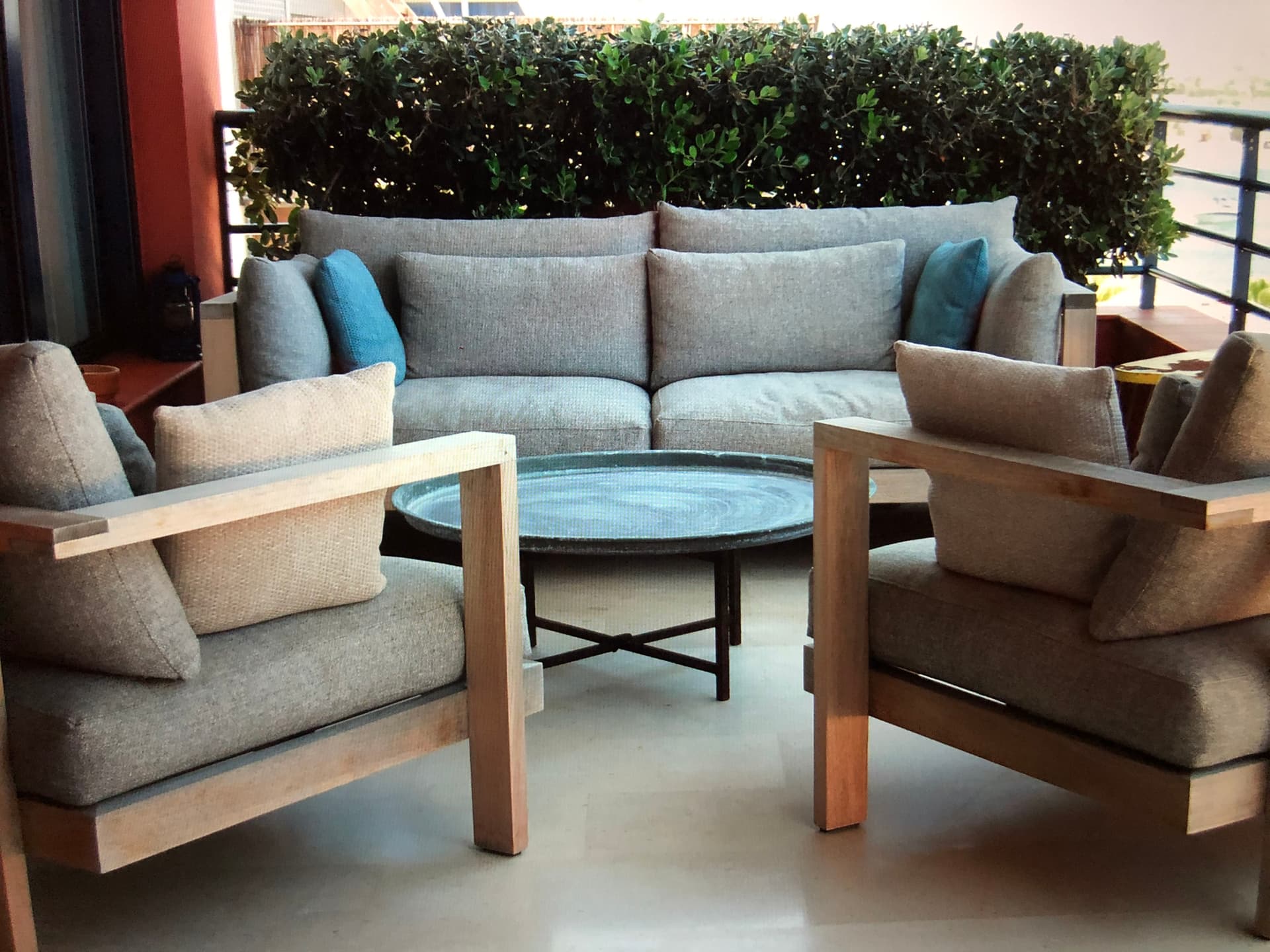 Sheltered terrace sofa behind a clipped hedge at an apartment on Illa Plana, Marina Botafoc, Ibiza