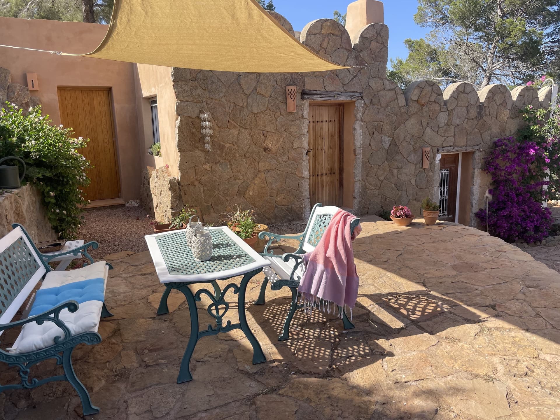 Table and chairs set in the original stone courtyard at Can Nardo, Sant Carles, Ibiza