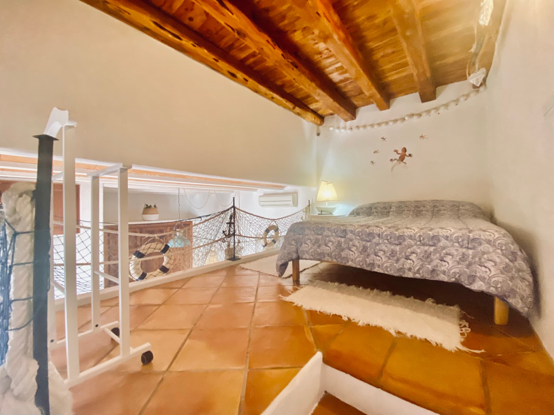 Bedroom with a beamed ceiling and terracotta floor at Piso Granate, Dalt Vila, Ibiza