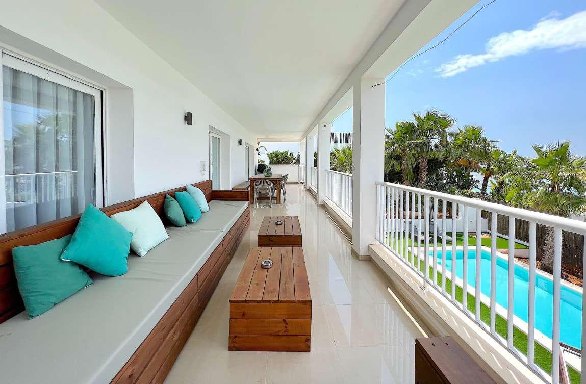 Long covered terrace with turquoise cushioned seating beside the pool, Marina Botafoc, Ibiza