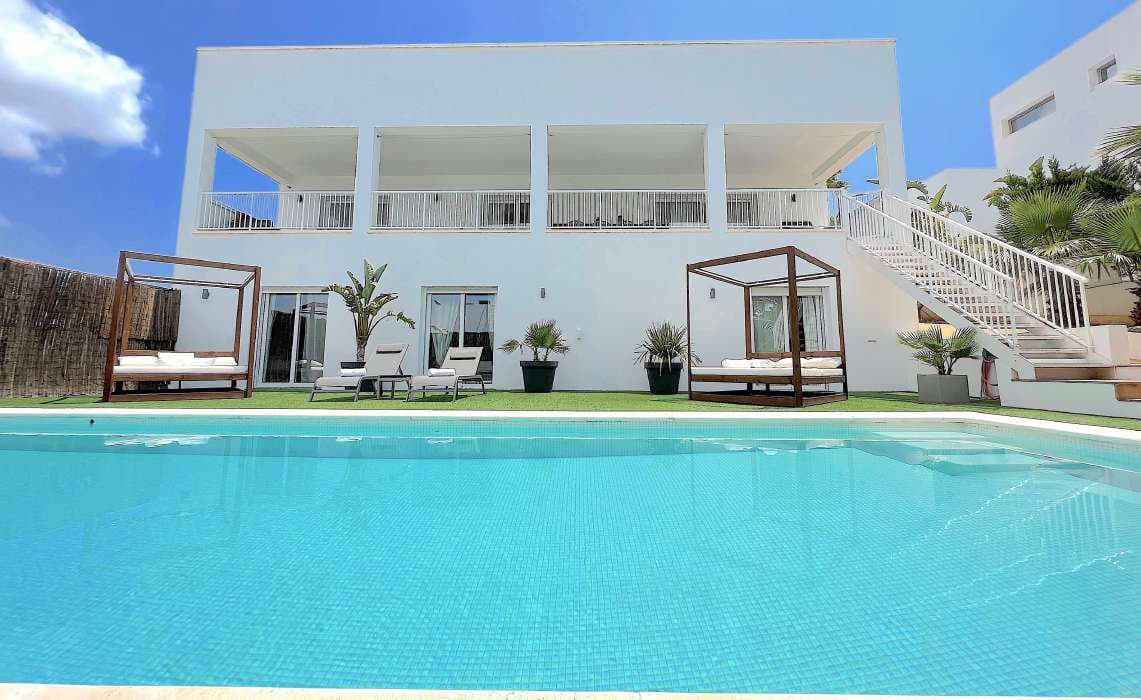 White daybeds set beside the swimming pool of an Ibicenco style villa, Marina Botafoc, Ibiza