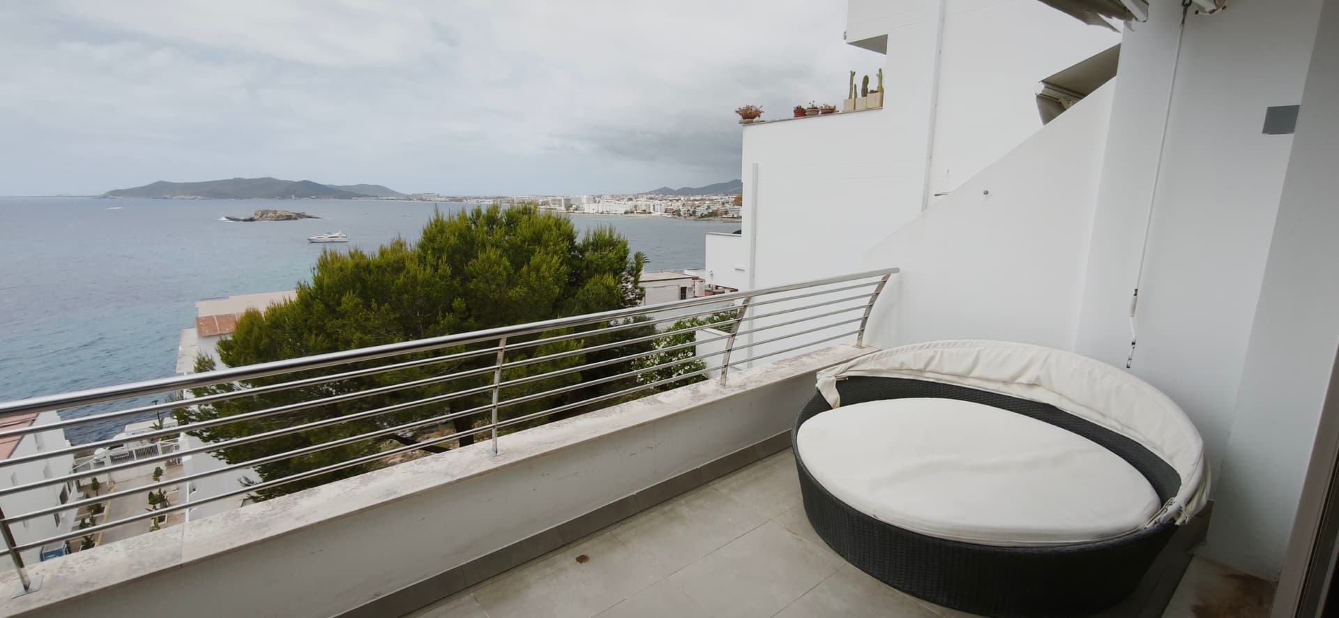 Terrace table with the sea and coastline beyond at Piso Amatista, Puig des Molins, Ibiza