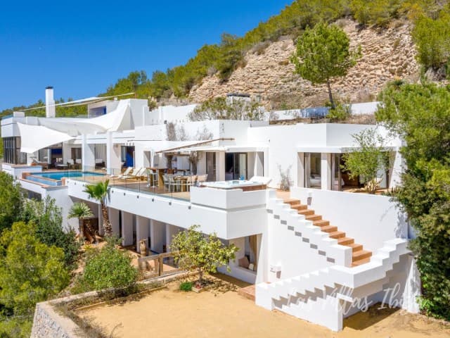 Whitewashed terraces and external steps set against the hillside at Casa Hacienda, Cas Mut, Ibiza