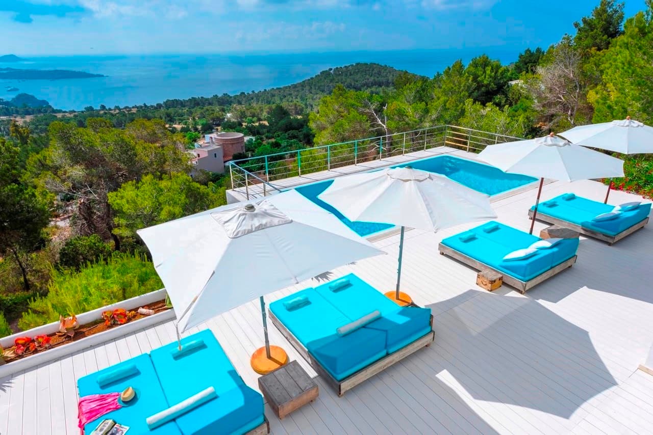 Blue daybeds beside the pool facing the sea at Villa Rome, Es Cubells, Ibiza