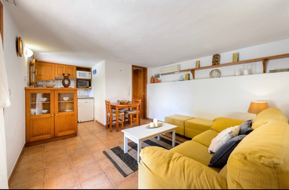 Living room with timber joinery and an ochre sofa, Sant Josep, Ibiza