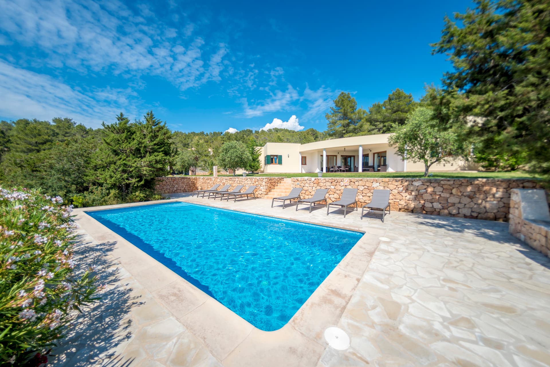 Swimming pool set on a stone terrace below the hills at Villa Sa Lluna, Sant Josep de Sa Talaia, Ibiza