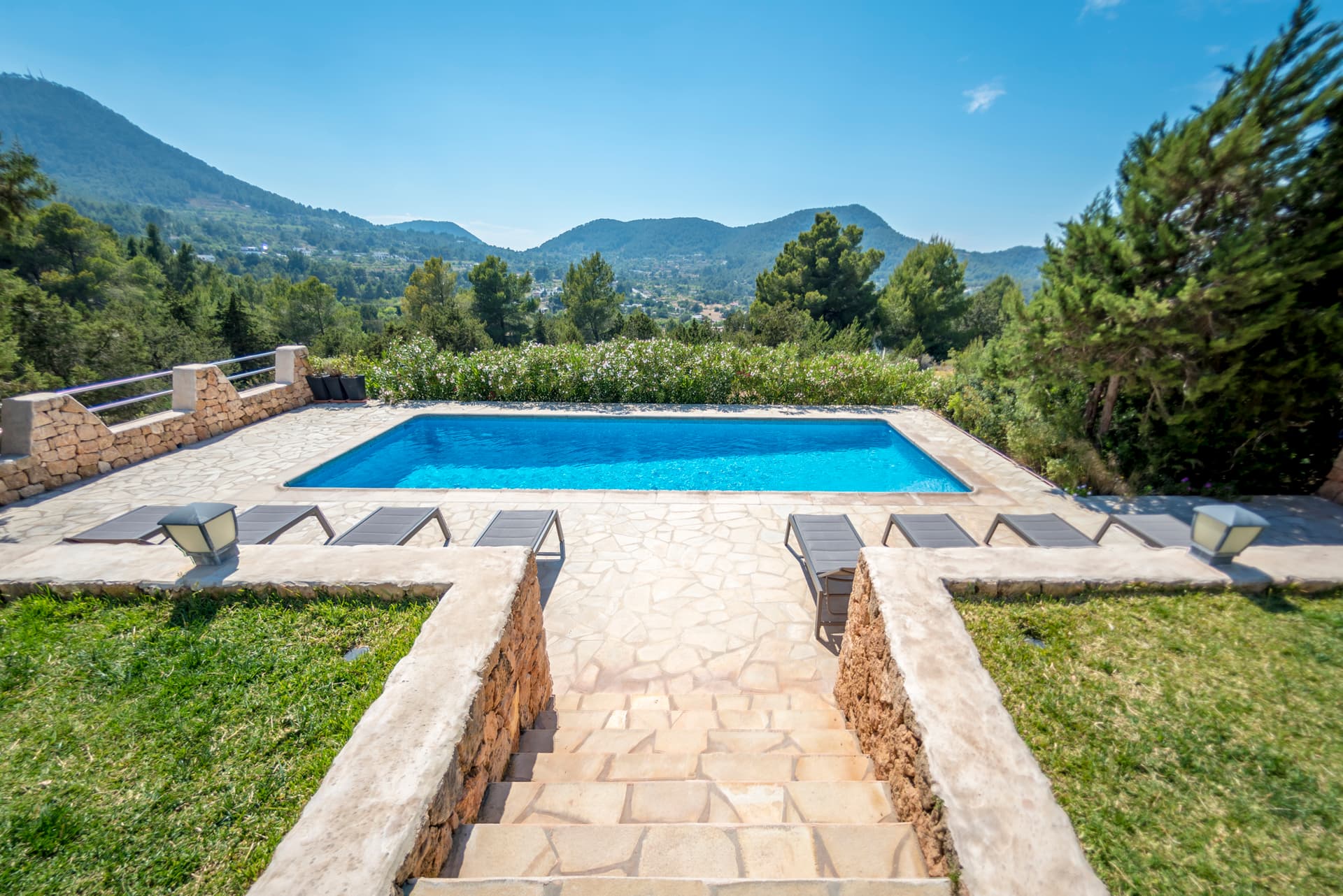 Sun loungers beside the pool with the mountains behind at Villa Sa Lluna, Sant Josep de Sa Talaia, Ibiza