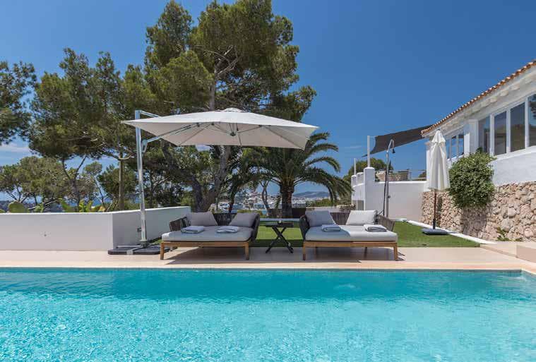 Parasol and mature palms beside the swimming pool at Villa Blanca, Cap Martinet, Ibiza