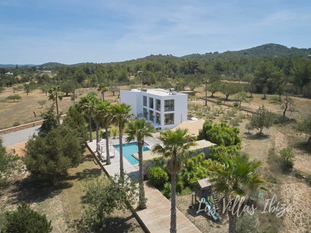 Minimalist white villa seen across the surrounding countryside, Sant Agusti, Ibiza