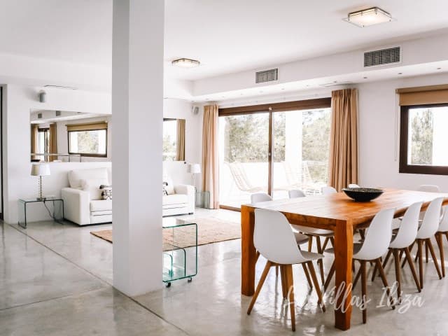 White living and dining space opening to the terrace at Villa Solset, Cala Salada, Ibiza