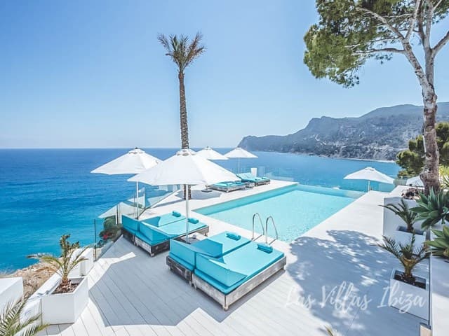 Infinity pool with parasols and daybeds looking straight out over the sea at Villa Emery, Es Cubells, Ibiza