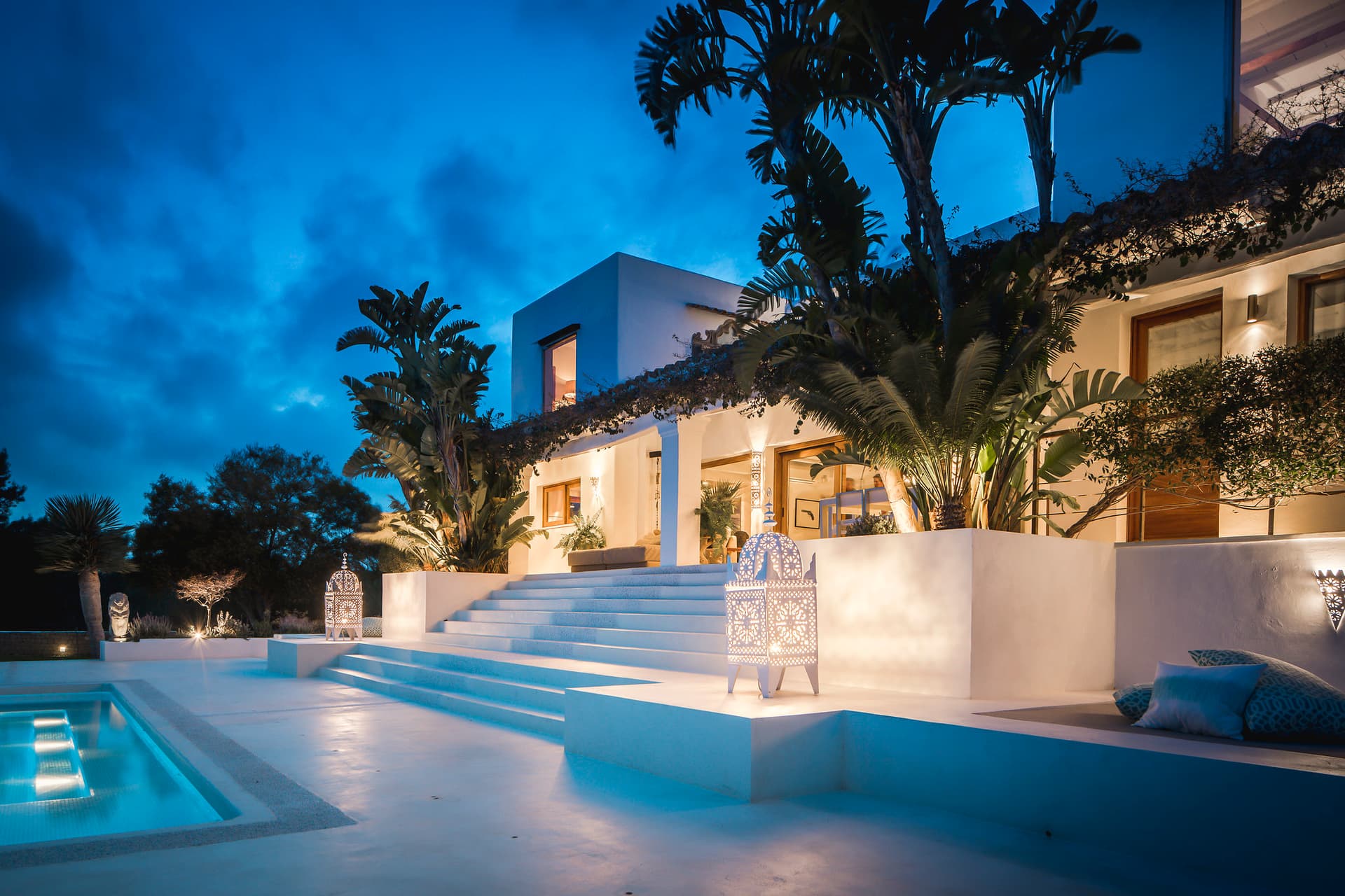 Villa Meghan lit at dusk with mature palms reflected in the pool, Sant Josep, Ibiza