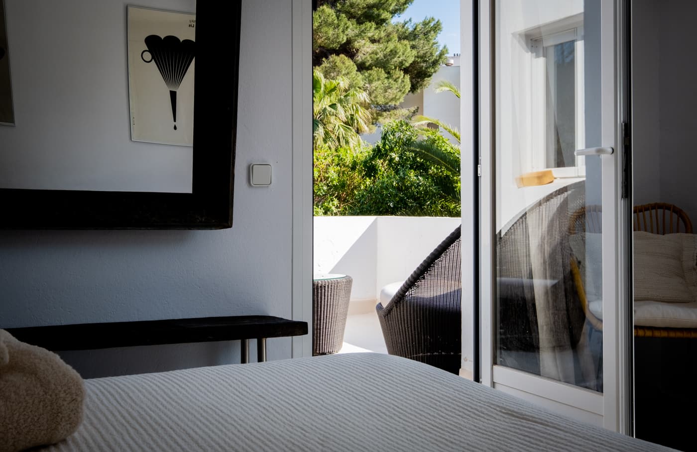 Bedroom with artwork and doors opening onto the terrace at Villa Zola, Roca Llisa, Ibiza