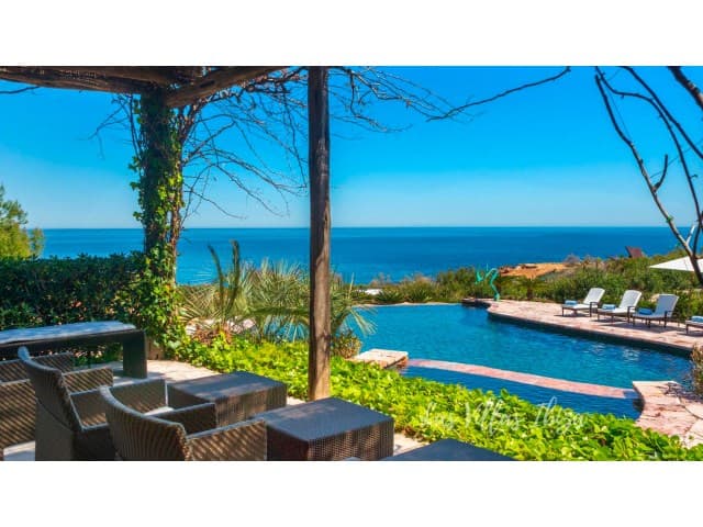 Shaded pergola and pool facing the open water at Villa Bellalux, Sant Carles, Ibiza