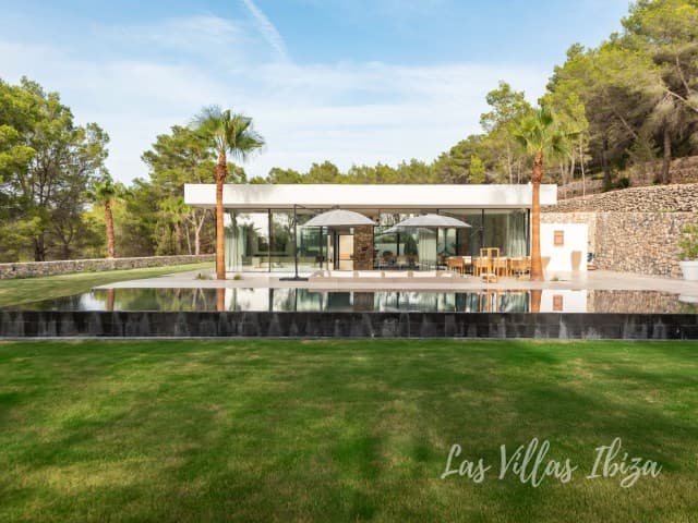 Lawns running to a dry stone wall beside the covered terrace at Villa Azul, Santa Gertrudis, Ibiza