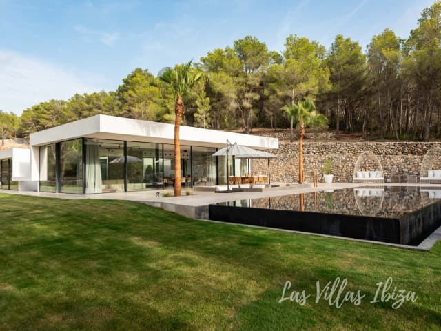 Villa Azul seen across its pool, a low contemporary house in Santa Gertrudis, Ibiza