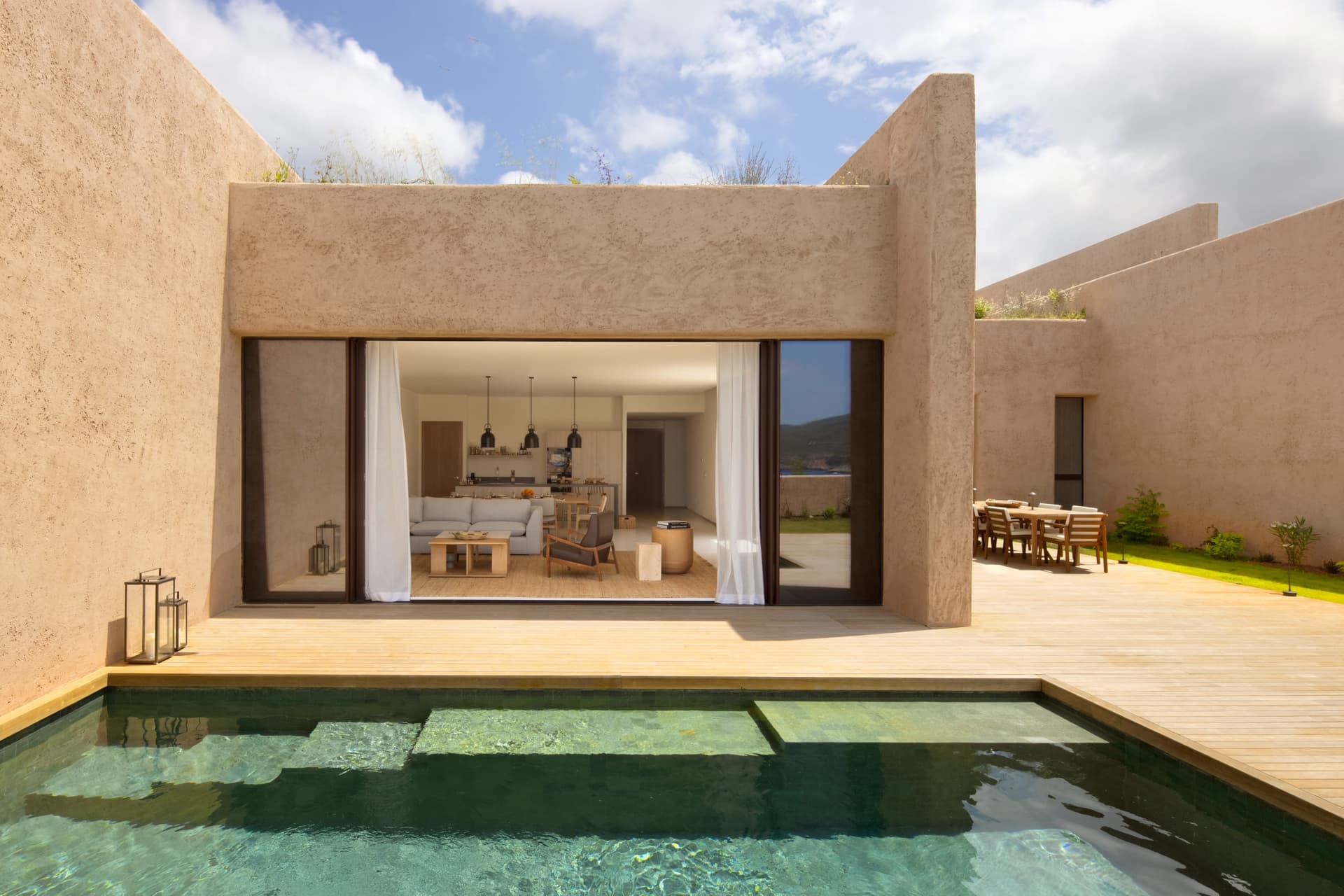 Swimming pool beside the rendered facade of a three bedroom residence, Portinatx, Ibiza