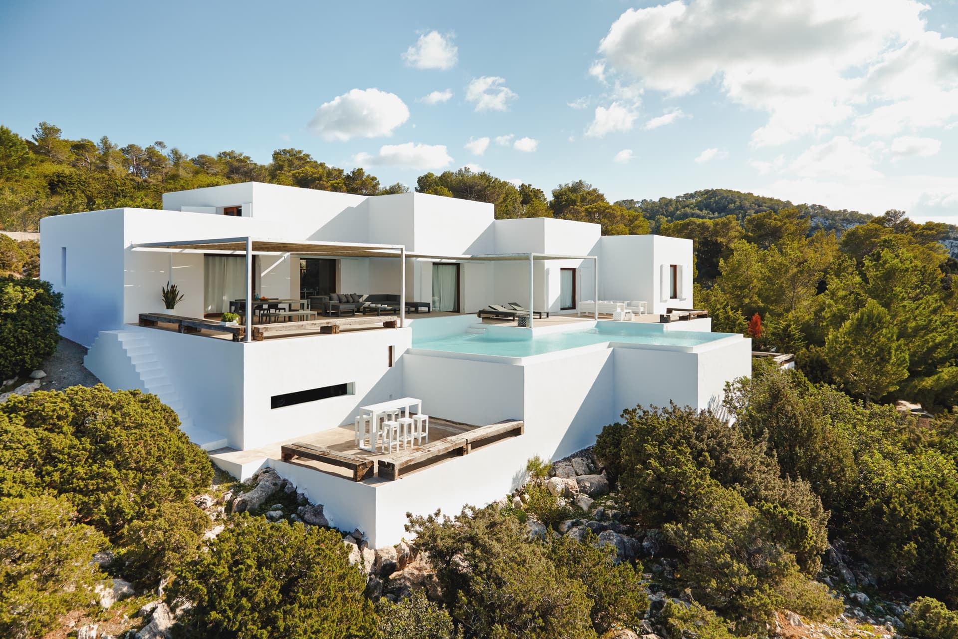 White villa set on the cliff among umbrella pines at Villa Na Xamena, Sant Joan de Labritja, Ibiza