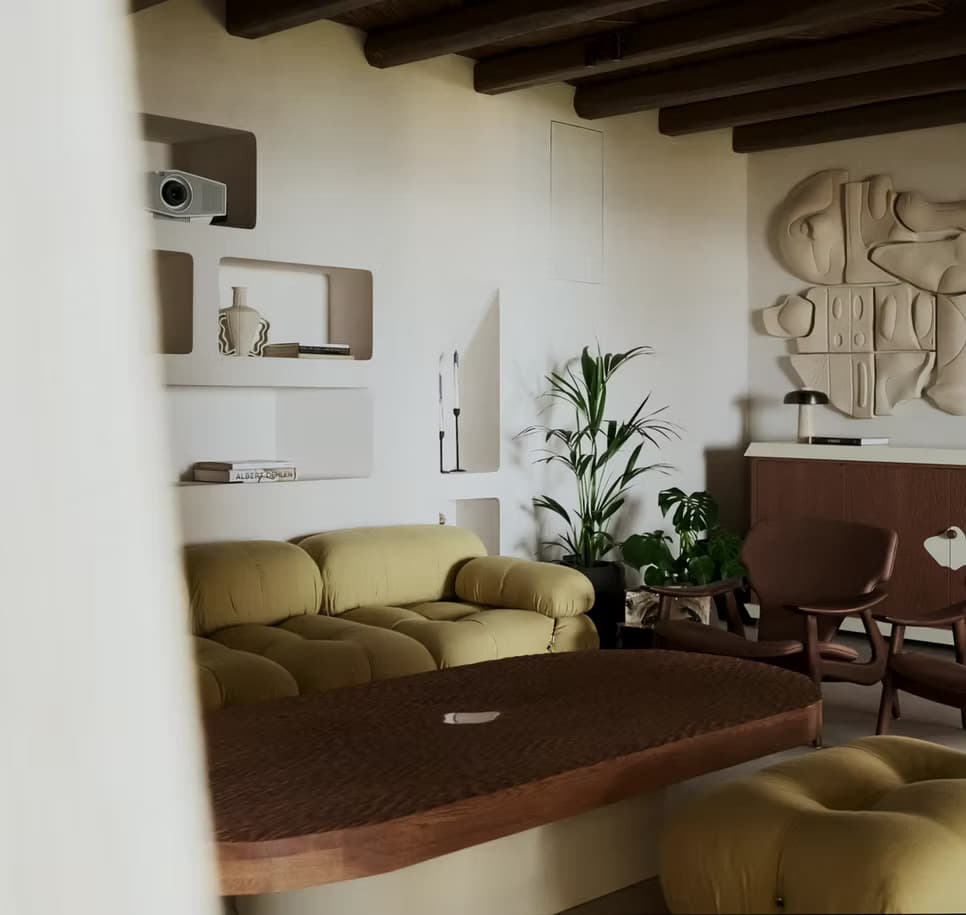 Living room with a beamed ceiling, olive toned seating and artwork at Villa Infinie, Es Cubells, Ibiza