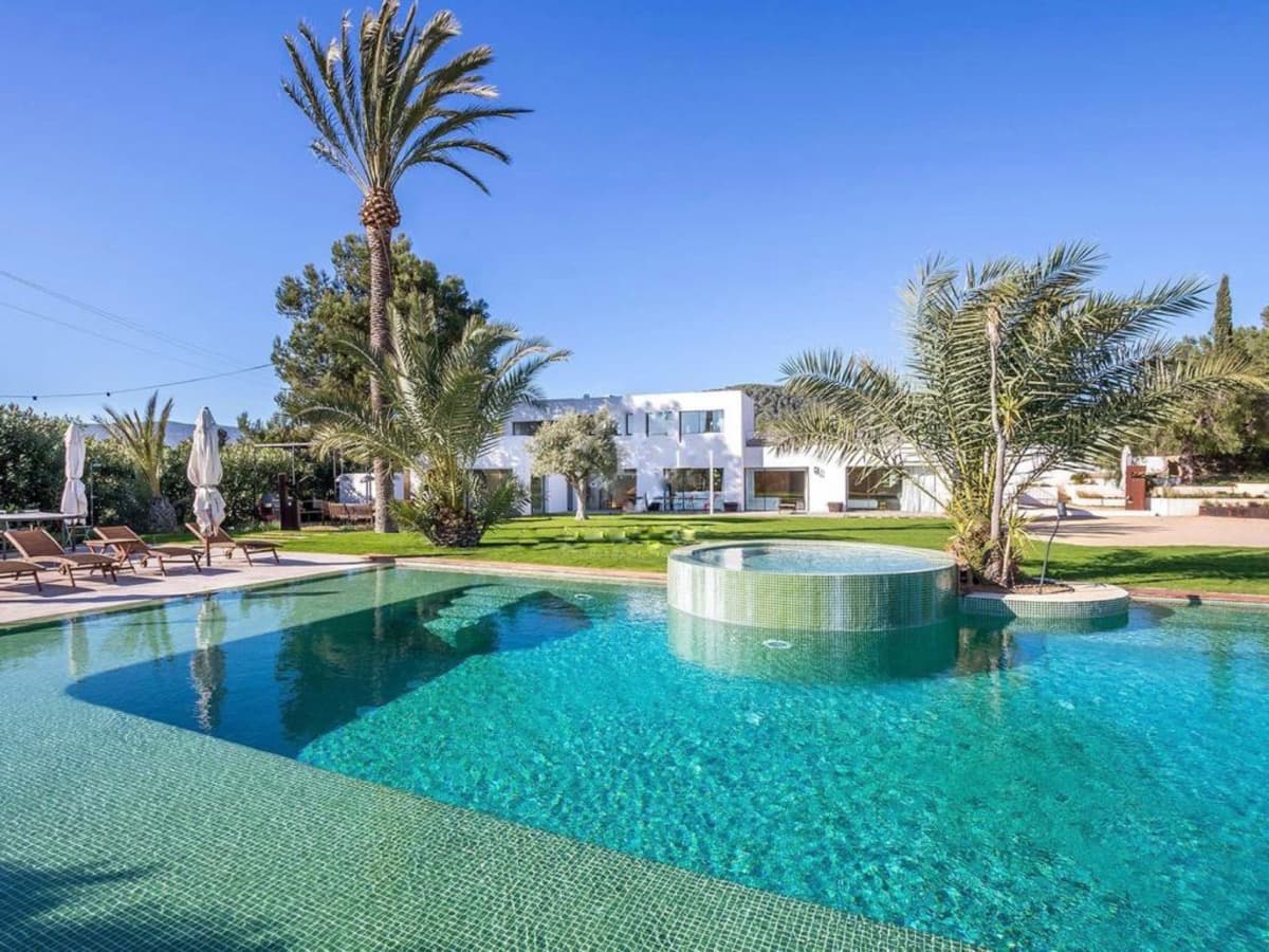 Mature palms and lawn around the swimming pool at Can Lucy Jondal, Cala Jondal, Ibiza