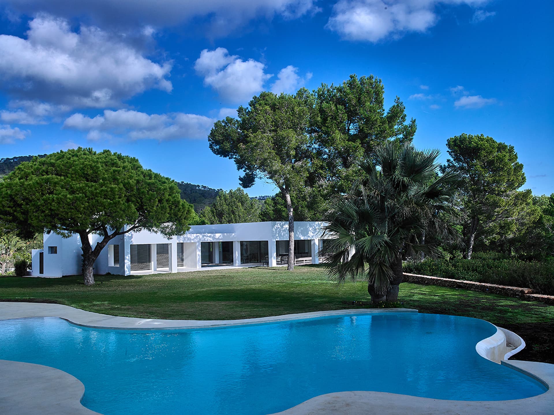 Curved swimming pool and lawn in front of Can Nuri, Sant Jordi de Ses Salines, Ibiza