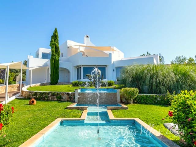 Whitewashed villa with a water feature, clipped hedging and cypress at Casa Flores, Can Furnet, Ibiza
