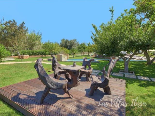 Timber deck with a rustic table and benches among the planting at Casa Flores, Can Furnet, Ibiza