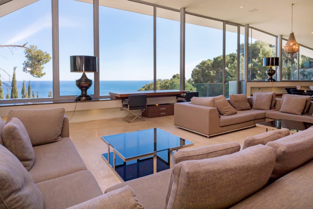 Living room with glass walls facing the sea at Villa Estelle, Roca Llisa, Ibiza