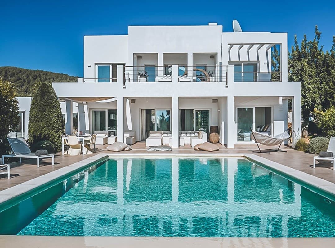Villa Nia seen across the pool, a white villa with stepped terraces, Cala Jondal, Ibiza