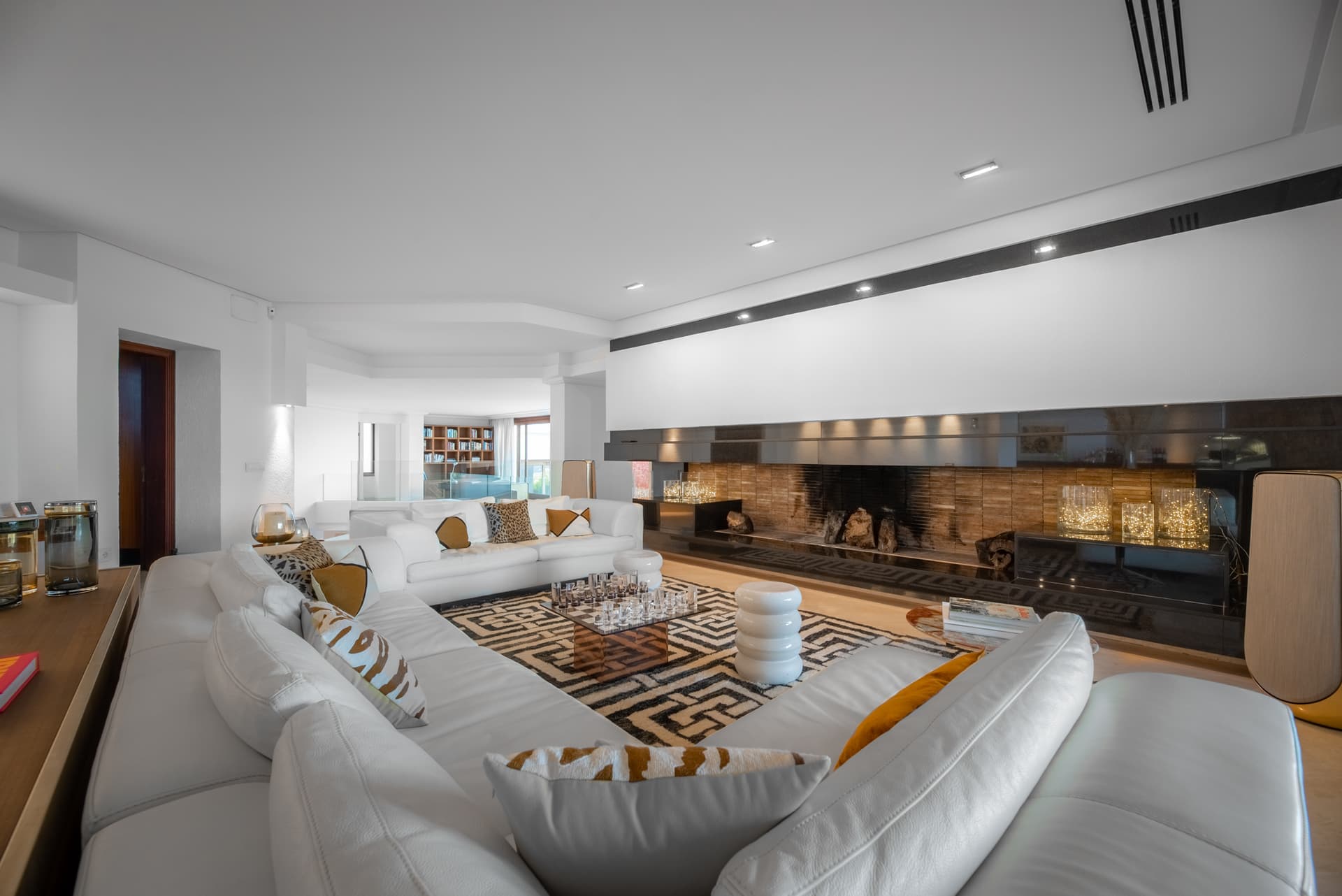 White living room with deep sofas and a fireplace at Villa Panacea, Sa Carroca, Ibiza