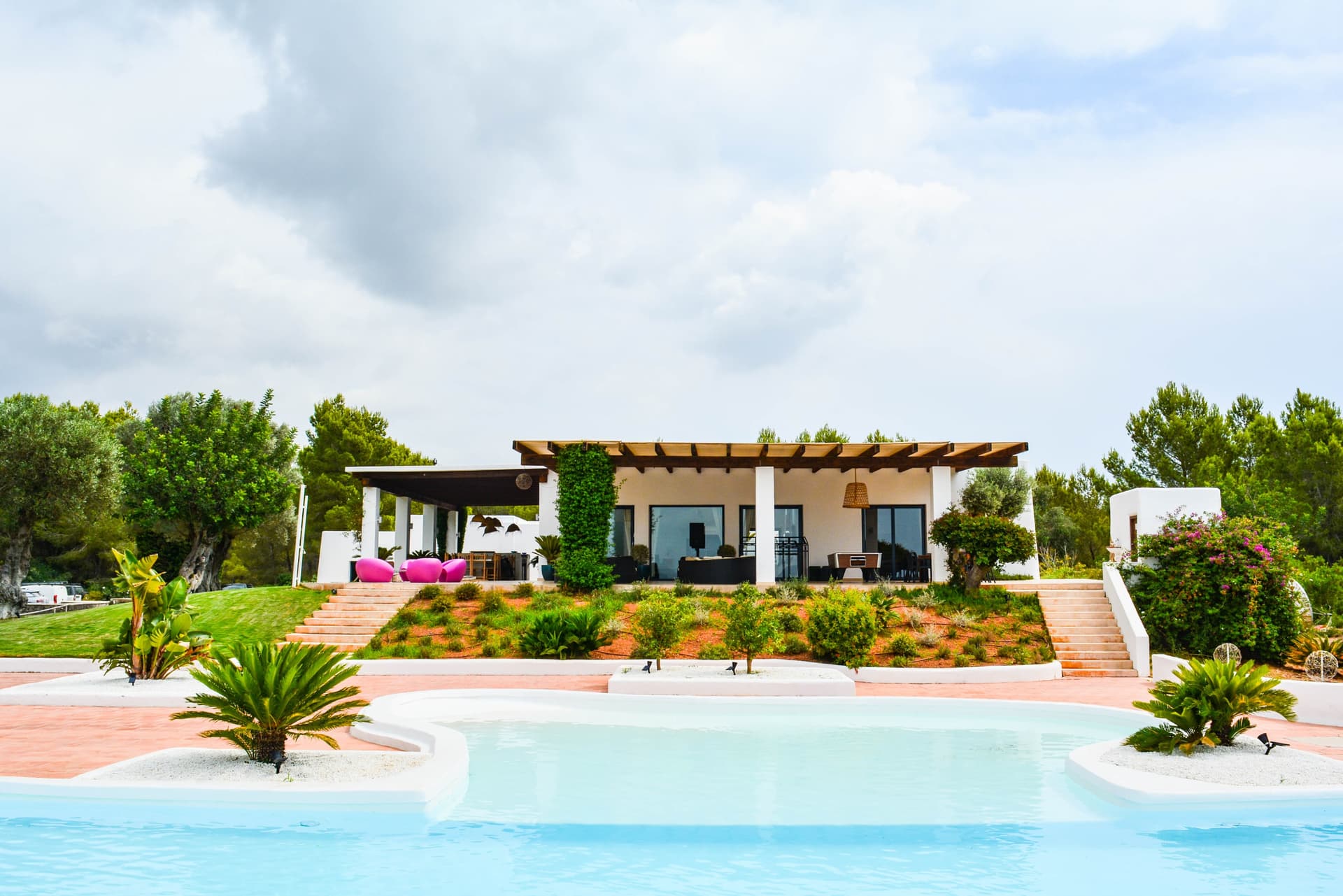 White villa with a timber pergola above the garden and pool at Villa Simona, Can Furnet, Ibiza