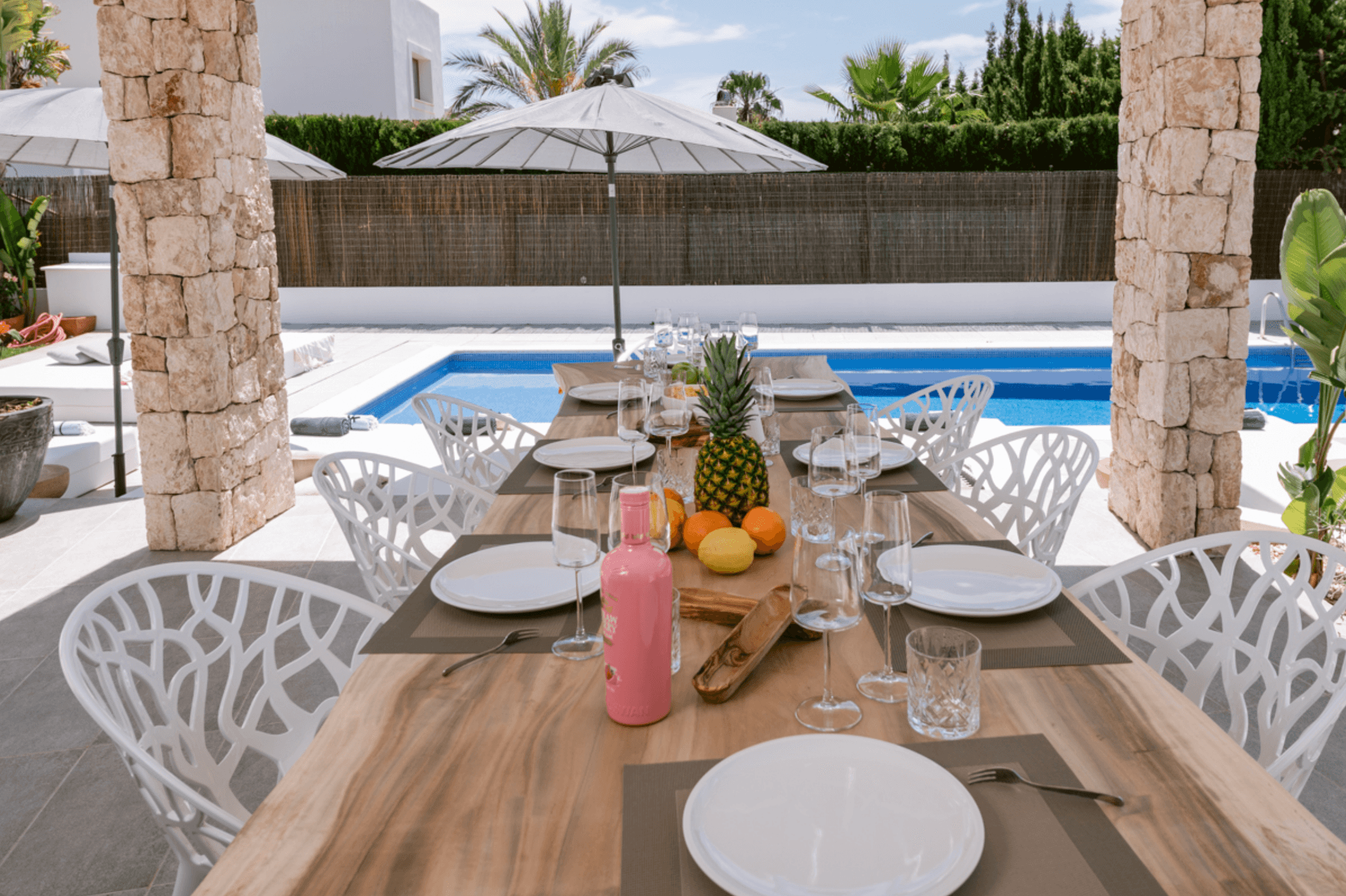 Outdoor dining beneath a pergola on stone columns beside the pool, Sa Carroca, Ibiza