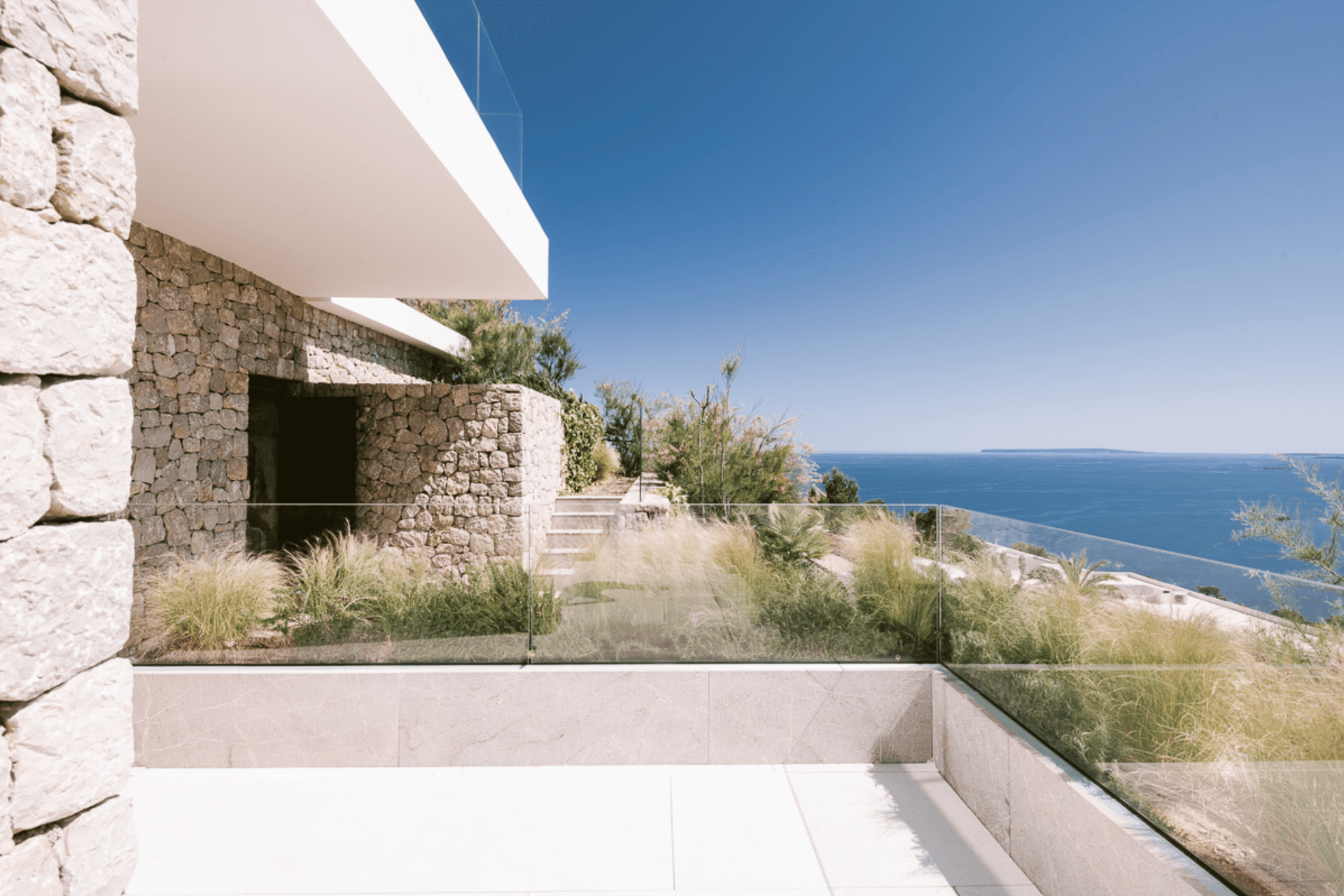 Dry stone wall and terrace looking out over the sea at a newly built villa, Ibiza
