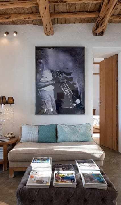 Living room with a beamed ceiling, artwork and turquoise cushions, Ibiza