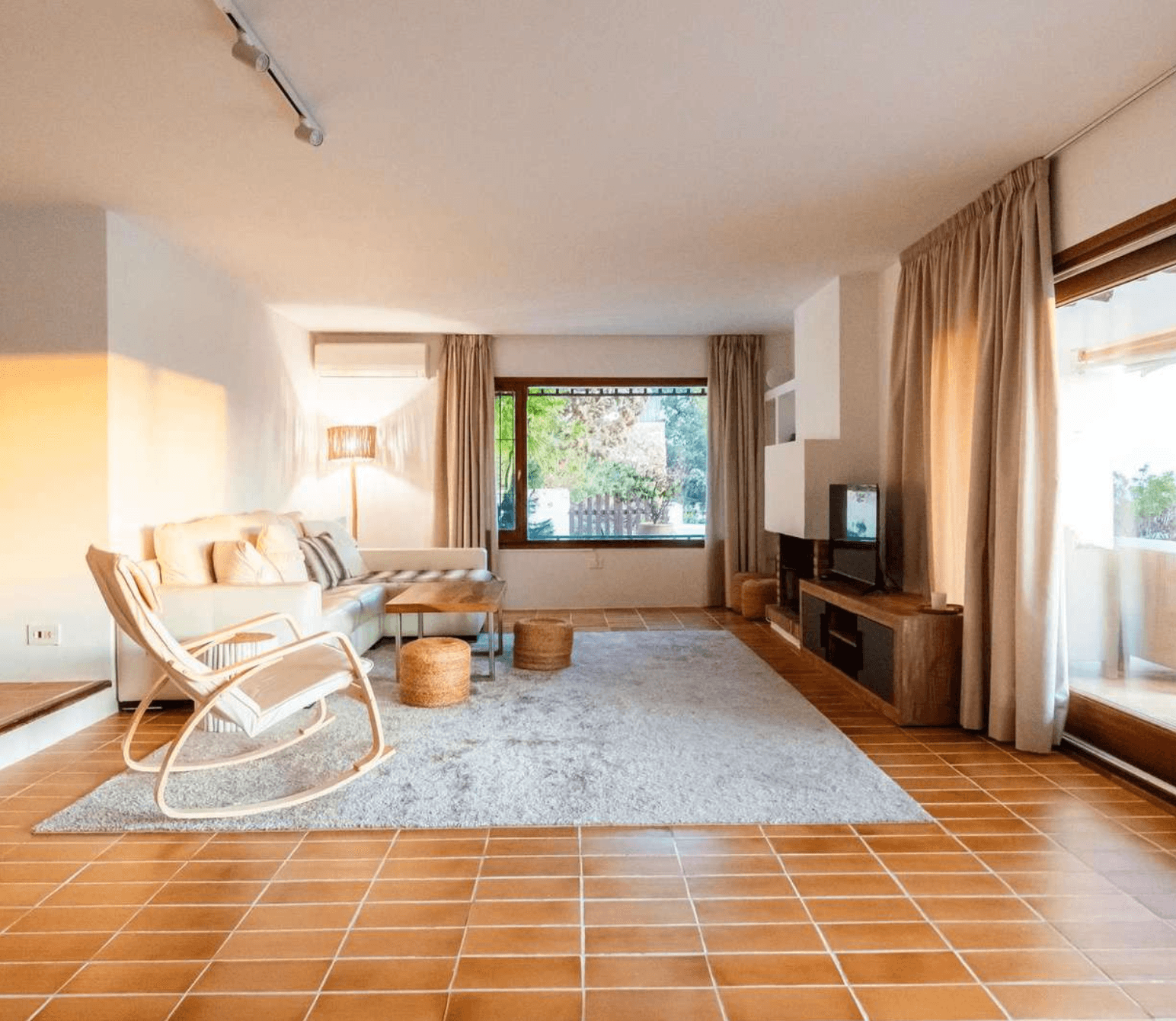 Living room with a rocking chair and terracotta tiled floor at Villa Pep Simon, Cap Martinet, Ibiza