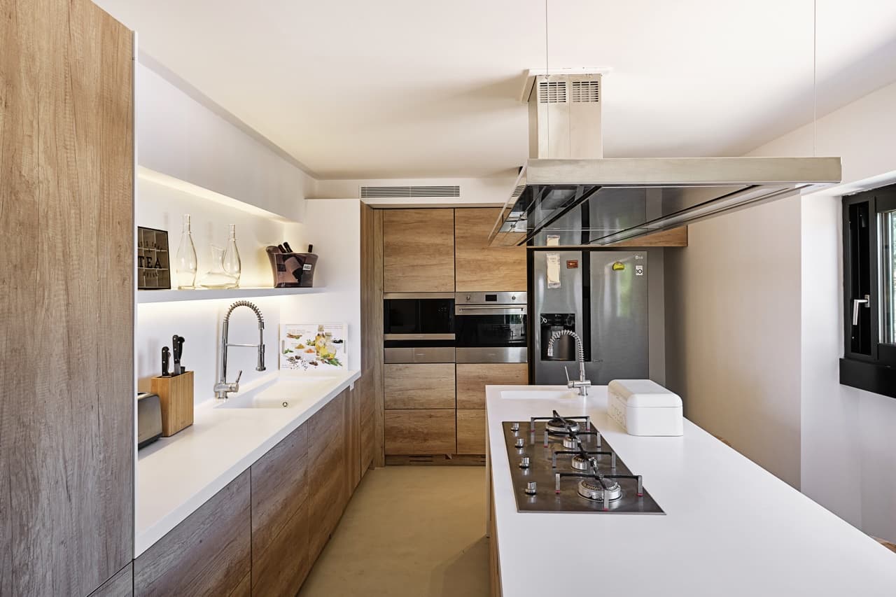 Galley kitchen in pale timber and stone at Villa Lantana, Santa Gertrudis, Ibiza